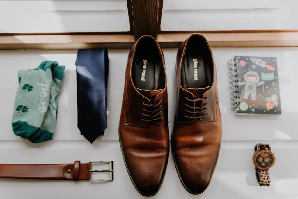Dodatki Pana Młodego - buty ślubne, skarpetki, zegarek i notes z przysięgą ślubną. 